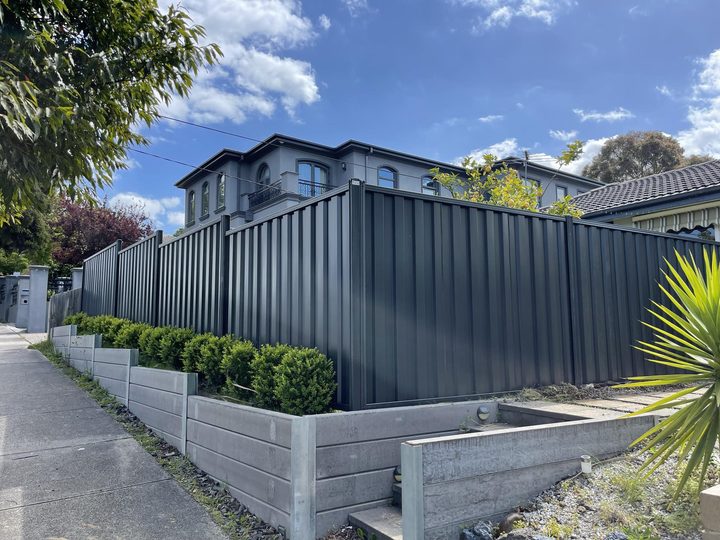 Dark Colorbond fence with concrete sleepers by HD Fencing