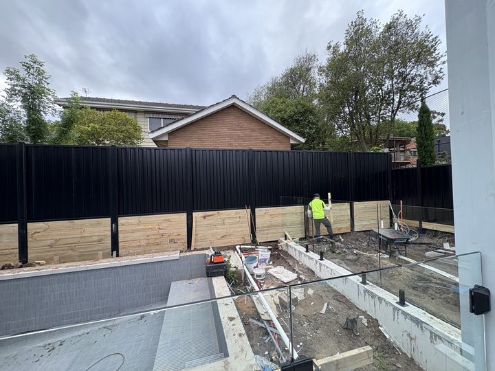Dark fence beside a patio by HD Fencing