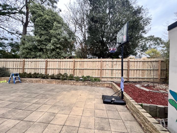 Timber fence beside a patio by HD Fencing